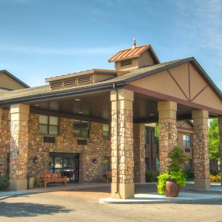 A hotel entrance with a stone facade and covered driveway.
