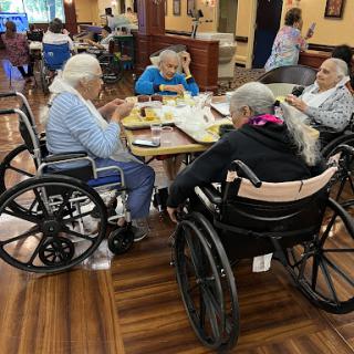 A group of seniors in wheelchairs enjoying a meal together, fostering community and social interaction.