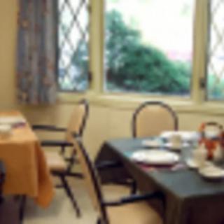 A cozy dining room with tables and chairs near large windows.