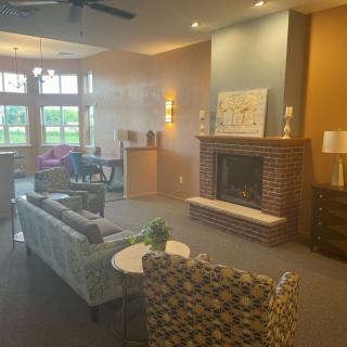 A cozy living room with a fireplace, sofas, chairs, and decorative elements.