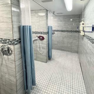 A modern and clean shower area with tiled walls and curtains for privacy.