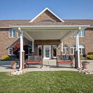 A brick building with a covered entrance and landscaped surroundings.