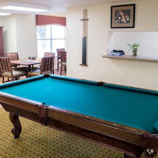 A cozy recreation room featuring a pool table and seating area.