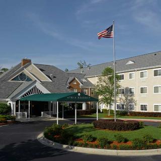 A hotel building with a flag flying above the entrance and well-maintained landscaping.