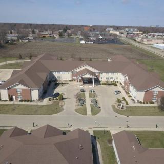 Aerial view of a large building complex with surrounding open land.
