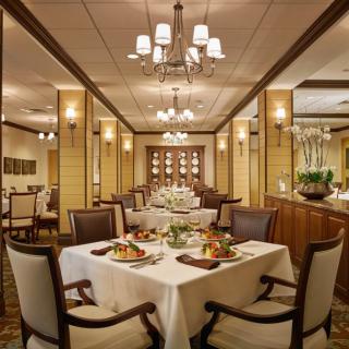 Elegant dining room with well-set tables and chandeliers.