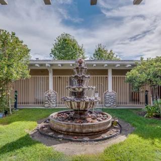 A tranquil courtyard with a multi-tiered fountain surrounded by lush greenery.