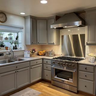 A modern kitchen with stainless steel appliances and gray cabinets.