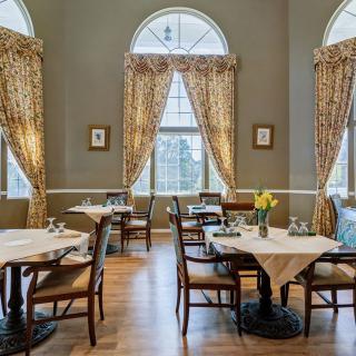Elegant restaurant interior with classic decor and large windows.