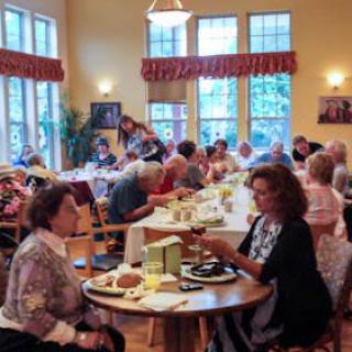 A lively community gathering with people dining together indoors.