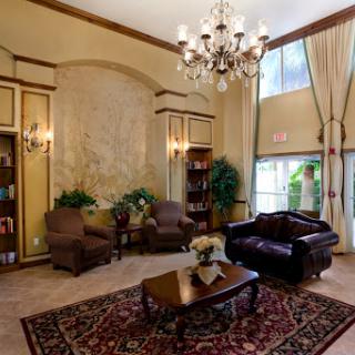 A cozy and elegant lobby featuring comfortable seating, decorative plants, and a stylish chandelier.