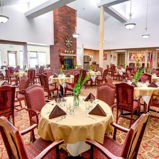 A spacious dining room with elegantly set tables and comfortable chairs.