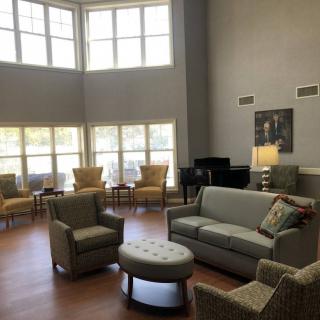 A spacious, well-lit living room featuring modern furniture and large windows.