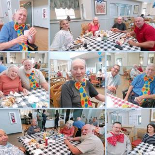 A joyful group of seniors enjoying a meal together in a community dining area.