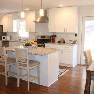 A modern kitchen with white cabinets, a central island, and pendant lighting.