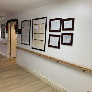 A hallway with framed certificates and decorations on the wall.