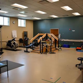 A well-equipped rehabilitation facility featuring various exercise equipment and a dedicated workout area.