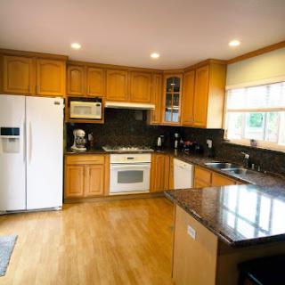 A well-lit modern kitchen featuring wooden cabinets and sleek appliances.