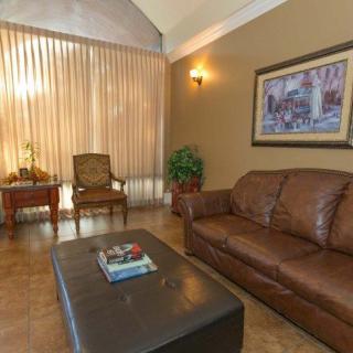 A cozy living room with a leather sofa, coffee table, and comfortable chairs by the window.
