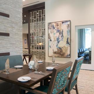 A modern dining room with elegant table settings and contemporary artwork.