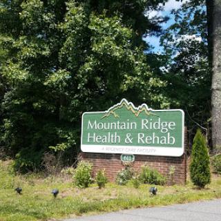 Sign for Mountain Ridge Health & Rehab facility, surrounded by greenery.