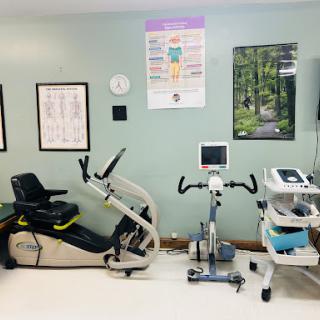 A well-equipped physical therapy room featuring various exercise machines and monitoring tools.