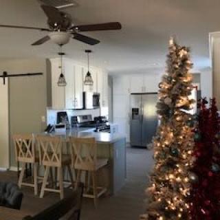 A cozy kitchen and living area decorated with a Christmas tree and holiday lights.