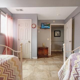 A cozy bedroom with twin beds, pastel d�cor, and soft lighting.