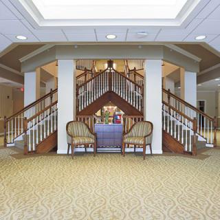 A spacious lobby area featuring a grand staircase and comfortable seating.