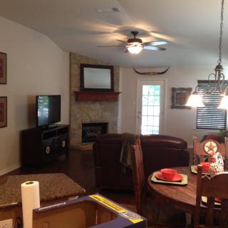 A cozy living room with a television, fireplace, and dining area.