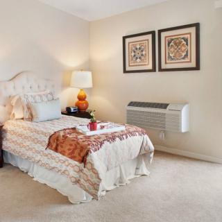 Cozy bedroom with a single bed, decorative elements, and warm lighting.