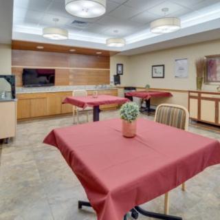 A modern dining area with tables covered in red tablecloths and contemporary lighting.