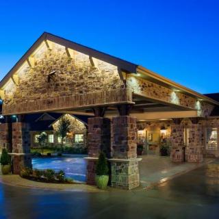 Illuminated building entrance at dusk with stone architecture.