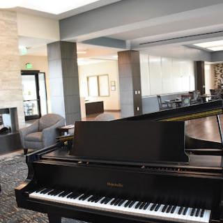 A sleek grand piano in a modern lounge area, inviting guests to enjoy music in a stylish setting.