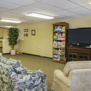 Cozy living room with a television, bookshelf, and comfortable seating.