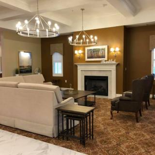 Contemporary living room with elegant chandeliers and a cozy fireplace.