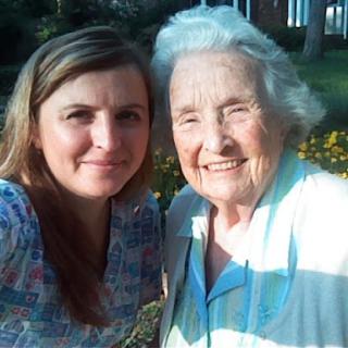 A joyful moment captured between a grandmother and granddaughter enjoying a sunny day outdoors.