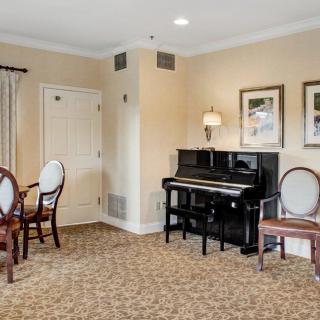 A cozy living room with a piano and elegant furnishings.