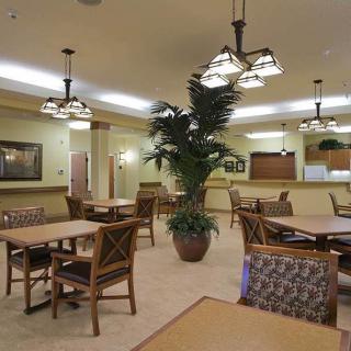 A modern dining area featuring wooden tables, chairs, and decorative lighting.