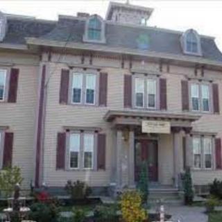 A historic building with distinctive architecture featuring multiple windows and a prominent roof.