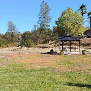 A scenic view of a park with a pavilion surrounded by trees and open grassy areas.
