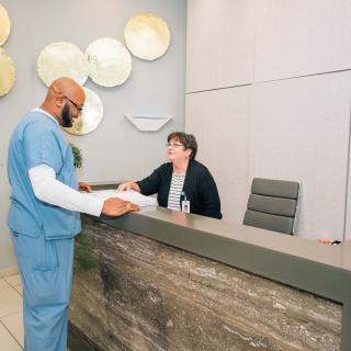 A professional interaction at a medical office reception.