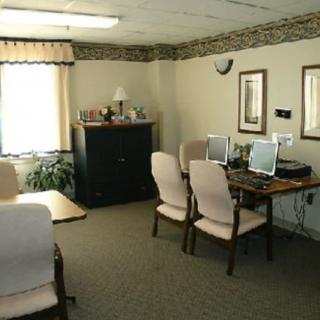 A small office space with desks, chairs, and computers.