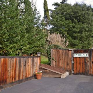 A wooden gate with an 'Entrance' sign, surrounded by trees.