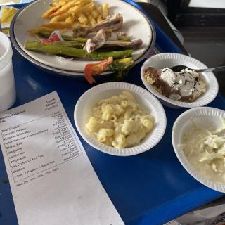 A meal served on a blue tray featuring fries, asparagus, chicken, and various side dishes.