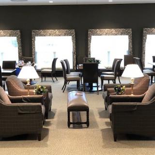 A cozy lounge area with comfortable seating and natural light from large windows.
