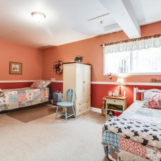 A cozy children's bedroom with twin beds and warm-colored walls.