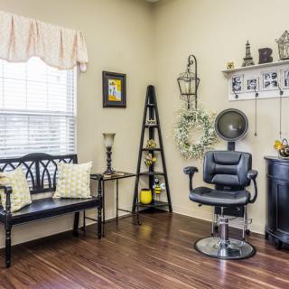 A cozy salon interior featuring a barber chair and waiting area with elegant decor.
