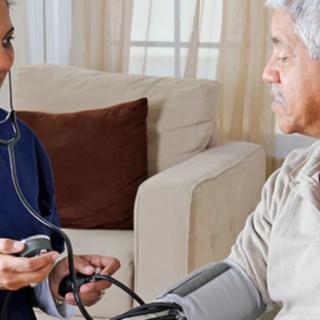 A nurse measuring the blood pressure of an elderly patient at home.