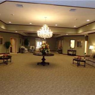 A spacious and elegantly decorated lobby with a central chandelier and furnishings.